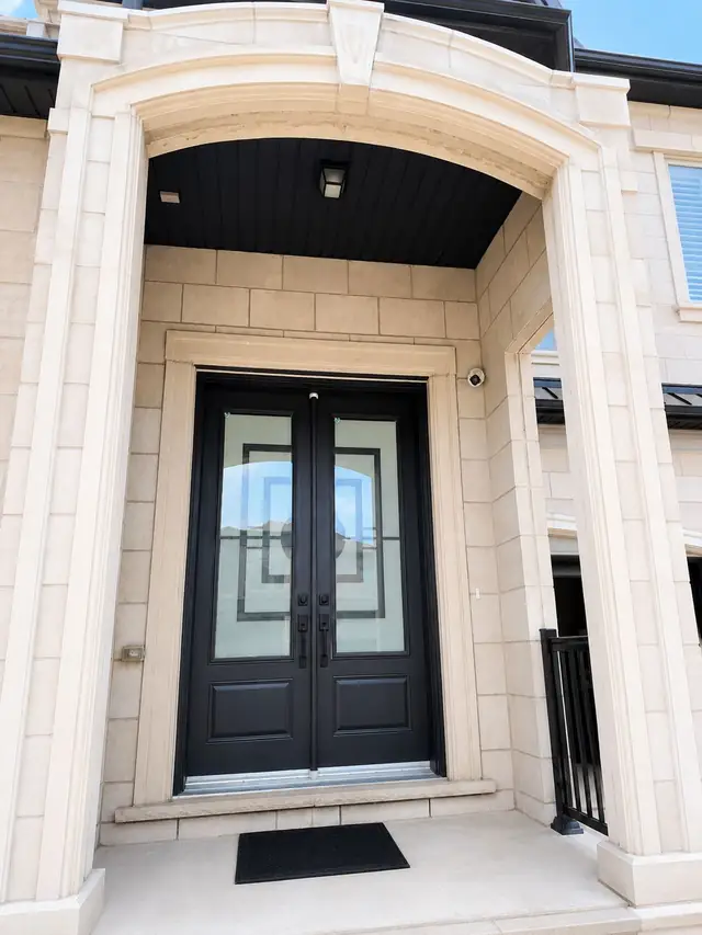 Front entrance of a stone home covered by a security camera